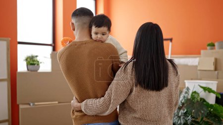 Foto de Pareja e hijo abrazándose de pie en casa nueva - Imagen libre de derechos