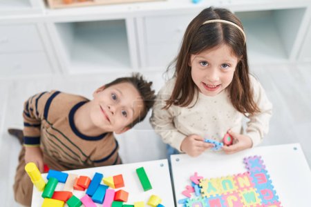 Téléchargez les photos : Adorable garçon et fille jouant avec des blocs de construction et puzzle de vocabulaire à la maternelle - en image libre de droit