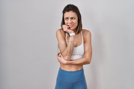 Photo for Hispanic woman wearing sportswear over isolated background looking stressed and nervous with hands on mouth biting nails. anxiety problem. - Royalty Free Image