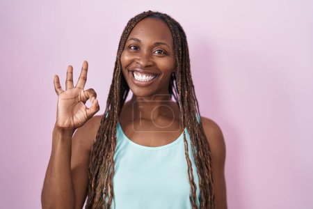 Photo for African american woman standing over pink background smiling positive doing ok sign with hand and fingers. successful expression. - Royalty Free Image