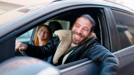 Foto de Hombre y mujer pareja sonriendo confiado coche de conducción en la calle - Imagen libre de derechos