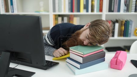 Photo for Young redhead man student sleeping on books at library university - Royalty Free Image