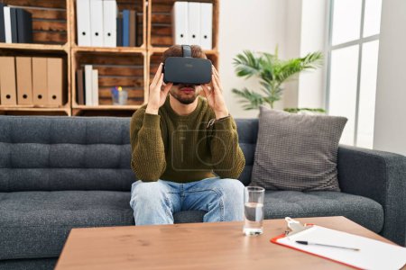 Photo for Young arab man patient having mental session using vr glasses at psychology center - Royalty Free Image