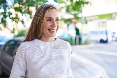 Photo for Young blonde woman smiling confident looking to the side at street - Royalty Free Image