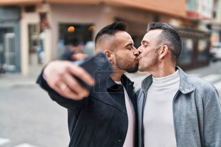 Photo for Two men couple make selfie by smartphone kissing at street - Royalty Free Image
