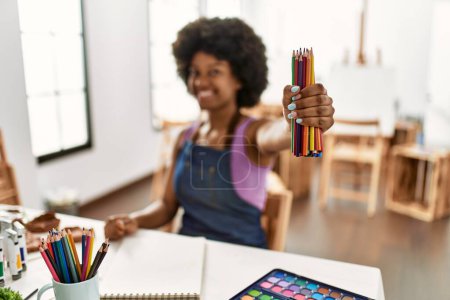 Photo for Young african american woman smiling confident holding color pencils at art studio - Royalty Free Image
