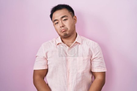 Photo for Chinese young man standing over pink background depressed and worry for distress, crying angry and afraid. sad expression. - Royalty Free Image
