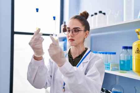 Téléchargez les photos : Jeune femme scientifique tenant des éprouvettes en laboratoire - en image libre de droit