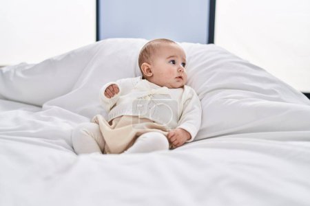 Photo for Adorable baby relaxed lying on bed at bedroom - Royalty Free Image