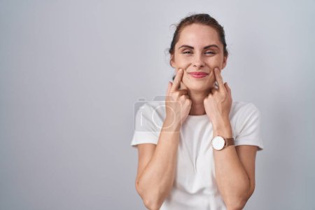 Téléchargez les photos : Belle femme brune debout sur fond isolé souriant avec la bouche ouverte, les doigts pointant et forçant sourire joyeux - en image libre de droit