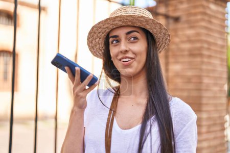 Foto de Young hispanic woman tourist smiling confident talking on the smartphone at street - Imagen libre de derechos