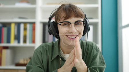 Photo for Young caucasian woman using computer wearing headphones at library university - Royalty Free Image