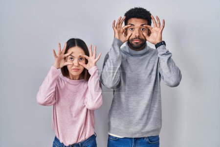 Photo for Young hispanic couple standing together trying to open eyes with fingers, sleepy and tired for morning fatigue - Royalty Free Image
