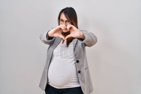 Photo for Pregnant business woman standing over white background smiling in love showing heart symbol and shape with hands. romantic concept. - Royalty Free Image