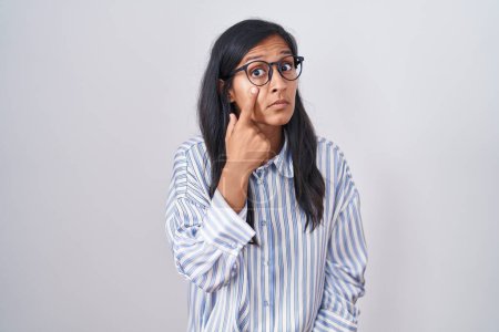 Photo for Young hispanic woman wearing glasses pointing to the eye watching you gesture, suspicious expression - Royalty Free Image