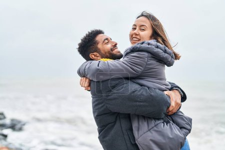 Foto de Hombre y mujer pareja sonriendo confiado abrazándose unos a otros en la playa - Imagen libre de derechos
