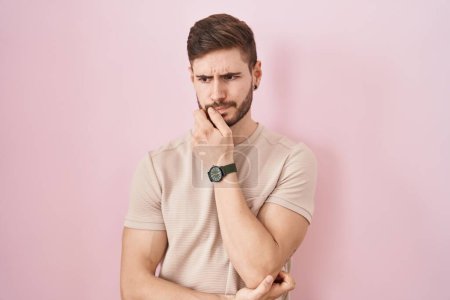 Photo for Hispanic man with beard standing over pink background looking stressed and nervous with hands on mouth biting nails. anxiety problem. - Royalty Free Image