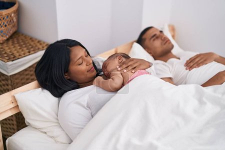 Photo for Hispanic family lying on bed at bedroom - Royalty Free Image