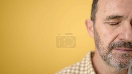 Photo for Middle age man with serious expression over isolated yellow background - Royalty Free Image