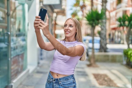 Photo for Young blonde woman smiling confident making selfie by the smartphone at street - Royalty Free Image