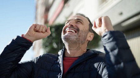 Foto de Hombre de mediana edad mirando al cielo con expresión ganadora en la calle - Imagen libre de derechos