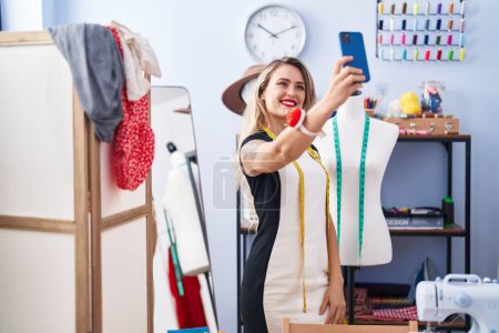 Photo for Young beautiful hispanic woman tailor smiling confident make selfie by smartphone at clothing factory - Royalty Free Image