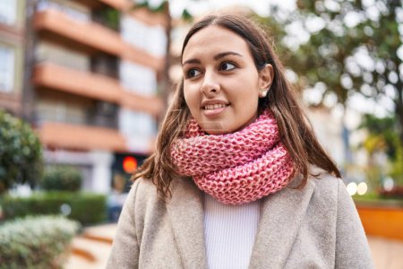 Téléchargez les photos : Young beautiful hispanic woman wearing scarf looking to the side at park - en image libre de droit