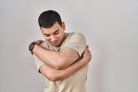 Photo for Young arab man wearing casual t shirt hugging oneself happy and positive, smiling confident. self love and self care - Royalty Free Image