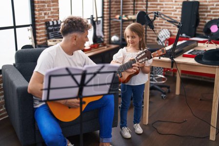 Téléchargez les photos : Père et fille jouant de la guitare classique et ukulélé au studio de musique - en image libre de droit