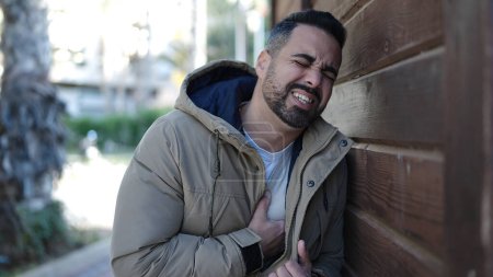 Téléchargez les photos : Young hispanic man suffering heart attack at street - en image libre de droit