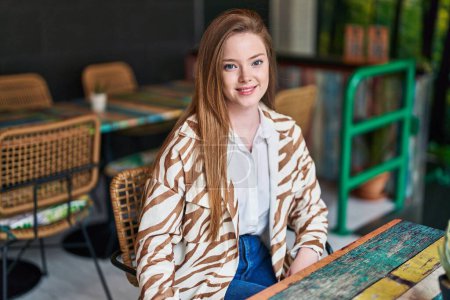 Téléchargez les photos : Jeune femme caucasienne souriant confiant assis sur la table au restaurant - en image libre de droit