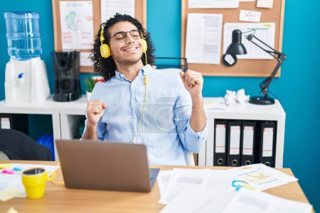 Photo for Young latin man business worker listening to music dancing at office - Royalty Free Image