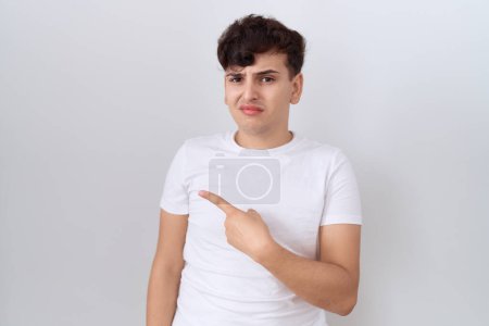Photo for Young non binary man wearing casual white t shirt pointing aside worried and nervous with forefinger, concerned and surprised expression - Royalty Free Image