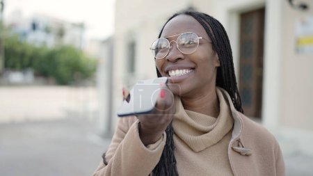 Téléchargez les photos : African woman sending voice message with phone at street - en image libre de droit