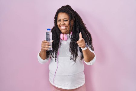 Photo for Plus size hispanic woman wearing sportswear and headphones pointing fingers to camera with happy and funny face. good energy and vibes. - Royalty Free Image