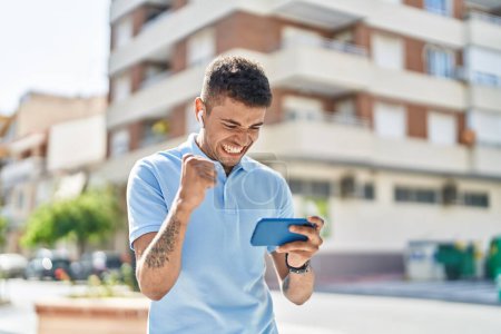 Téléchargez les photos : African american man smiling confident playing video game at street - en image libre de droit
