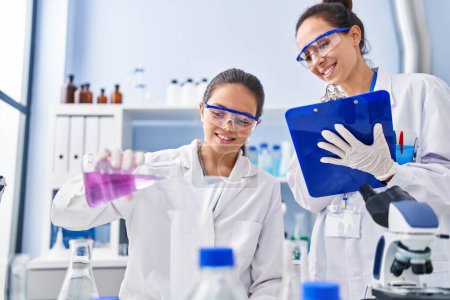 Foto de Mujer y niña vistiendo uniforme científico trabajando en el laboratorio - Imagen libre de derechos