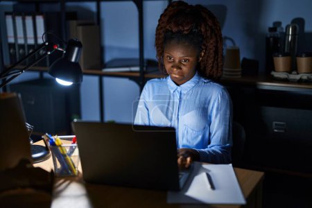 Photo for African woman working at the office at night depressed and worry for distress, crying angry and afraid. sad expression. - Royalty Free Image