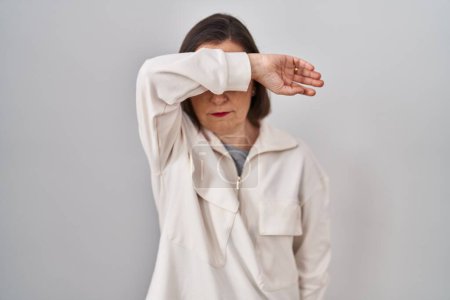 Photo for Middle age hispanic woman standing over isolated background covering eyes with arm, looking serious and sad. sightless, hiding and rejection concept - Royalty Free Image