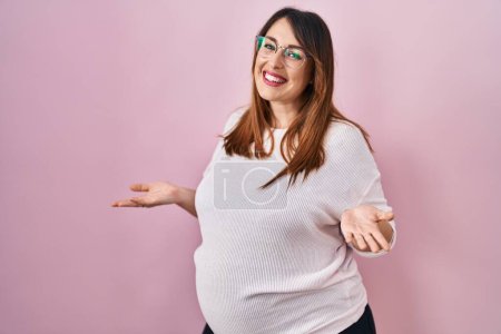 Photo for Pregnant woman standing over pink background clueless and confused with open arms, no idea concept. - Royalty Free Image