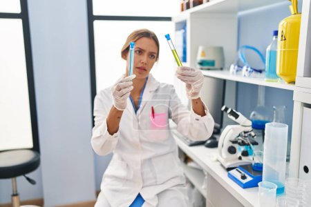 Photo for Young hispanic woman scientist holding test tubes at laboratory - Royalty Free Image