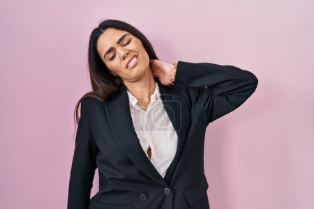 Photo for Young brunette woman wearing business style over pink background suffering of neck ache injury, touching neck with hand, muscular pain - Royalty Free Image