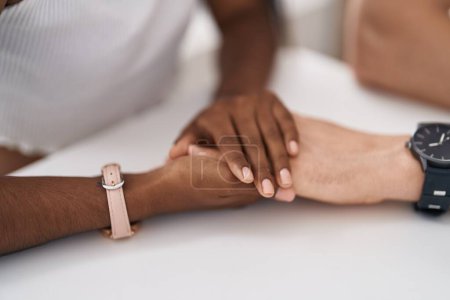 Téléchargez les photos : Homme et femme interracial couple avec les mains ensemble à la maison - en image libre de droit