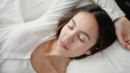 Téléchargez les photos : Jeune belle femme hispanique couchée sur le lit dormant dans la chambre - en image libre de droit