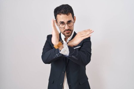 Foto de Hombre hispano de negocios guapo parado sobre fondo blanco expresión de rechazo cruzando brazos haciendo signo negativo, cara enojada - Imagen libre de derechos