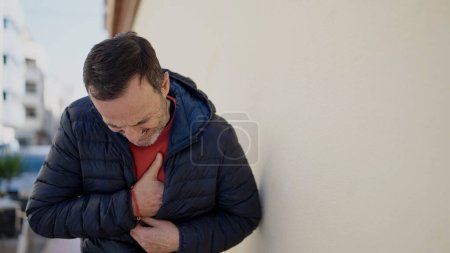 Foto de Middle age man suffering heart attack at street - Imagen libre de derechos
