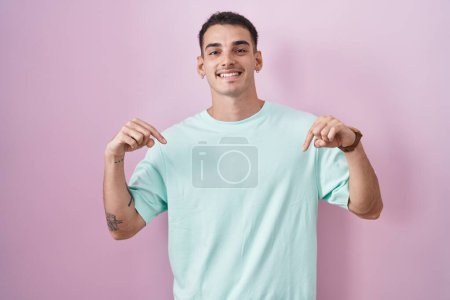 Photo for Handsome hispanic man standing over pink background looking confident with smile on face, pointing oneself with fingers proud and happy. - Royalty Free Image