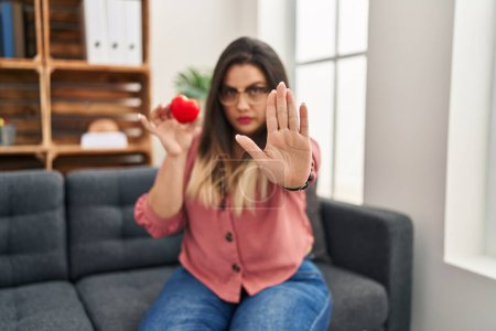 Photo for Young hispanic woman working on couple therapy at consultation office with open hand doing stop sign with serious and confident expression, defense gesture - Royalty Free Image