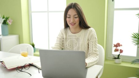 Foto de Young beautiful hispanic woman student smiling confident using laptop studying at home - Imagen libre de derechos