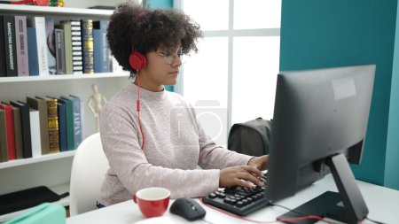 Téléchargez les photos : Jeune étudiante afro-américaine utilisant l'ordinateur pour étudier à l'université - en image libre de droit